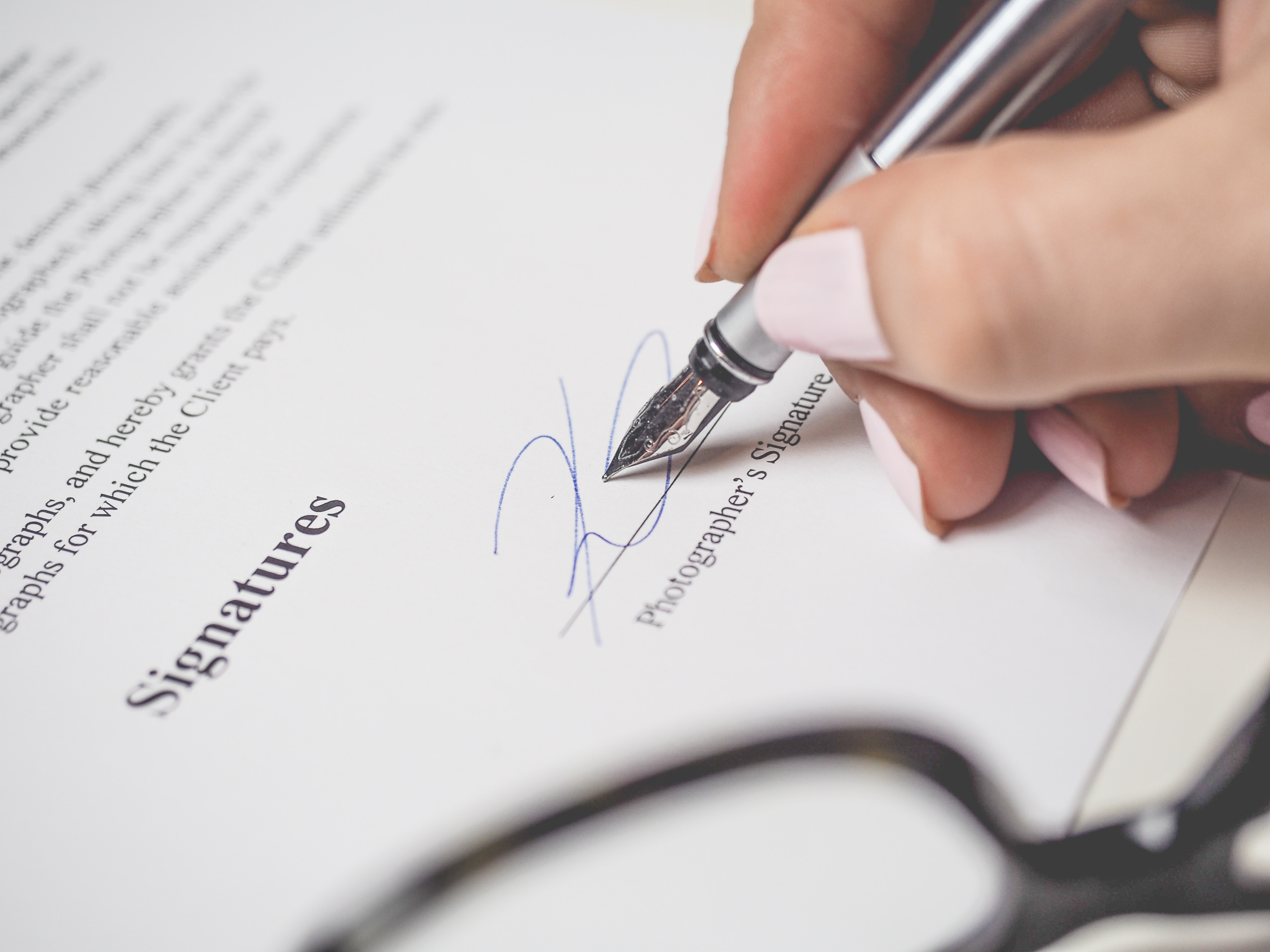 woman signing name on a legal document