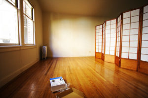 the empty room of an apartment with hardwood floors